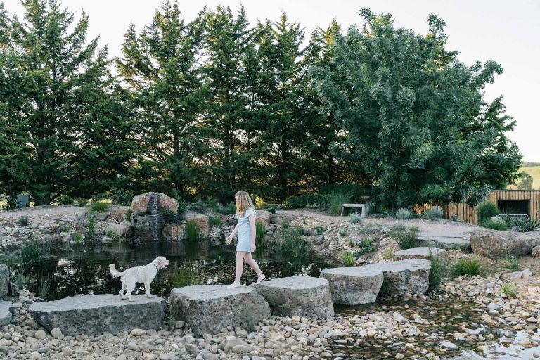 Kathleen Murphy's Garden - a young girl and her dog walking along stepping stones