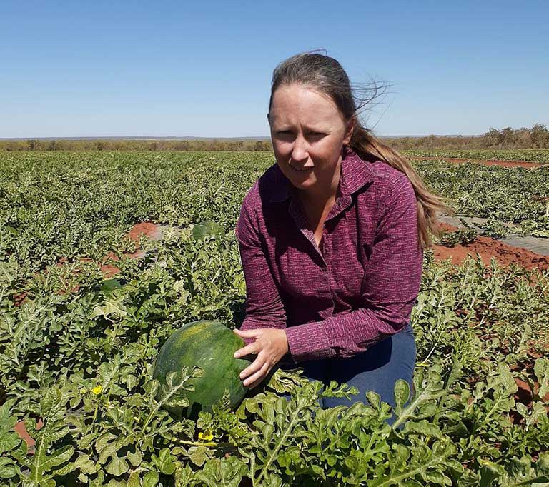 Teagan Alexander in a field, holding a melon Teagan Alexander in a field, holding a melon