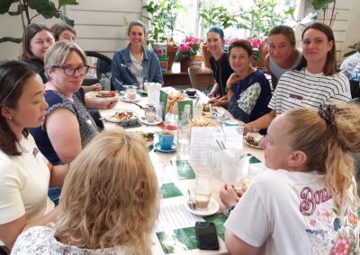 Group of women sitting around a lunch table in a cafe chatting