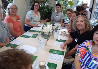 Group of women sitting around a lunch table in a cafe chatting