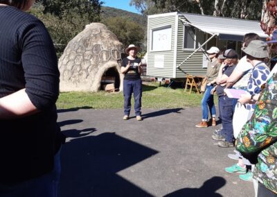 Thank you speech outside in a garden. There is a giant hive in the background, and a food truck, with people in the foreground.